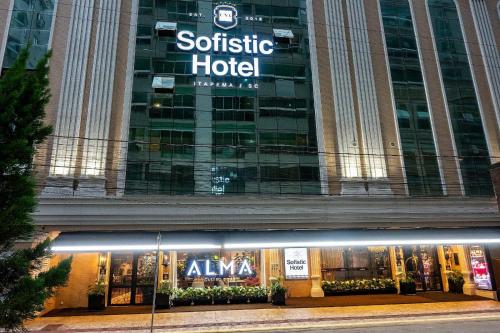 a store in front of a building with a sign on it at Sofistic Hotel in Itapema