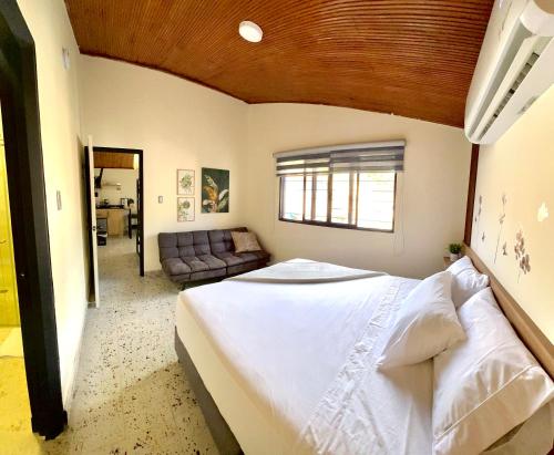 a bedroom with a large bed and a couch at Magiko Suites in Roldanillo