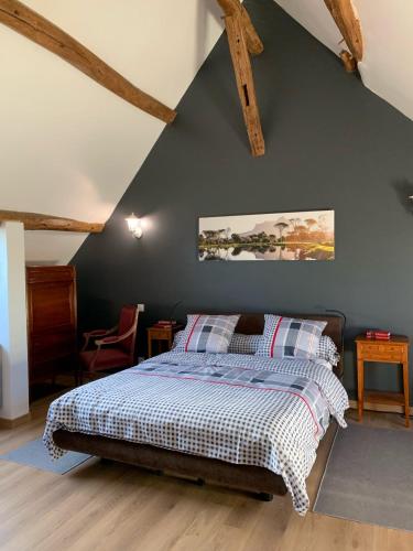 une chambre avec un lit avec un mur bleu dans l'établissement Le relais de poste Valero, à Serazereux