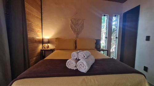a bedroom with a bed with towels on it at Casa jardim com ofurô - Chapada dos veadeiros in Cavalcante
