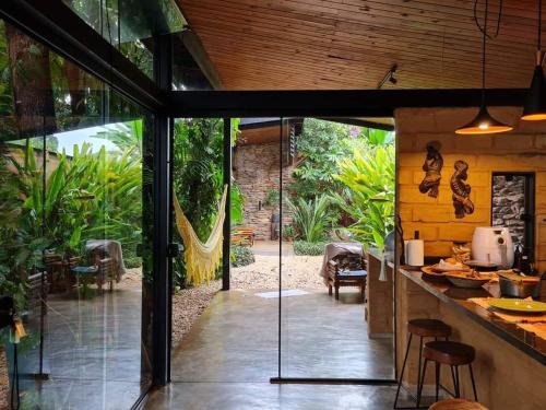 an outdoor kitchen with a view of a garden at Casa jardim com ofurô - Chapada dos veadeiros in Cavalcante