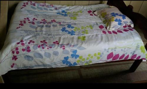 a bed with a white comforter with flowers on it at Atacuari Salvaje Tours Amazonas in San Juan de Atacuari