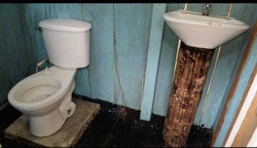 a bathroom with a toilet and a sink at Atacuari Salvaje Tours Amazonas in San Juan de Atacuari