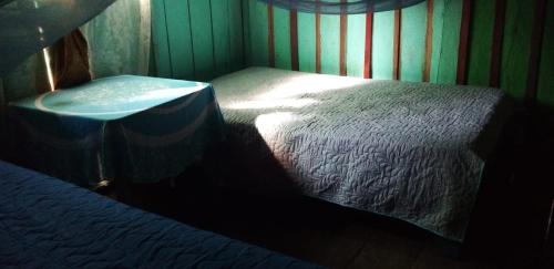 a small room with a bed and a sink at Atacuari Salvaje Tours Amazonas in San Juan de Atacuari
