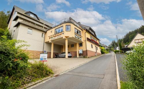 una grande casa gialla sul lato di una strada di Hotel Schöne Aussicht a Steinach