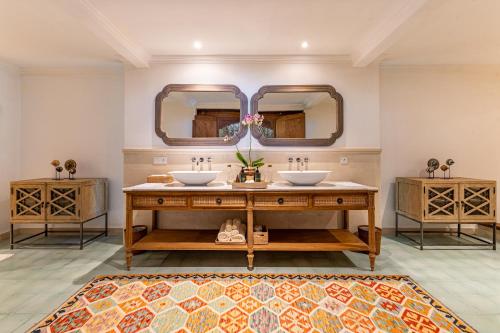 a bathroom with two sinks and two mirrors at Umah Lusa in Munduk