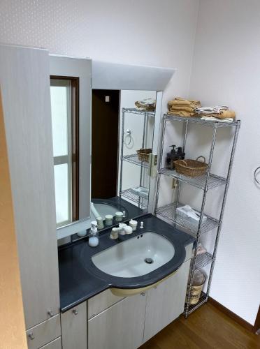 a bathroom with a sink and a mirror at I Love Izu in Futo