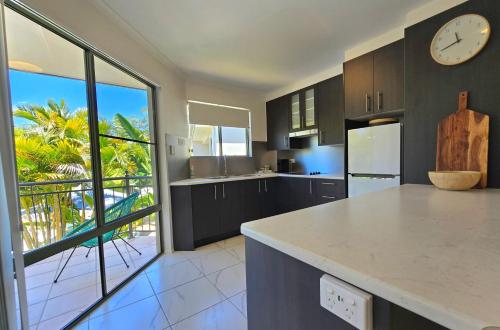 a kitchen with a large window and a clock on the wall at Noosa River Retreat Holiday Apartments in Noosaville