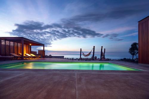 a swimming pool in front of a house with a playground at Norte Suites Boutique in Los Órganos