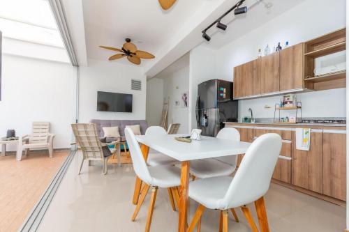 a kitchen and dining room with a white table and chairs at Apartamento Vacacional San Jeronimo Paraíso Bali in San Jerónimo