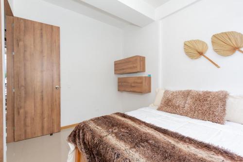 a bedroom with a bed and a wooden cabinet at Apartamento Vacacional San Jeronimo Paraíso Bali in San Jerónimo