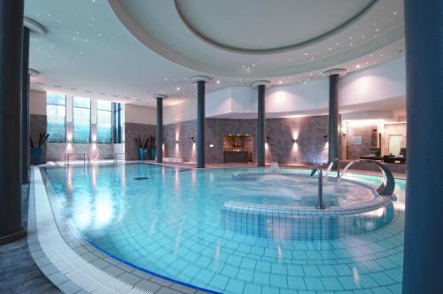 a large swimming pool in a building at Palácio Estoril Hotel, Golf & Wellness in Estoril