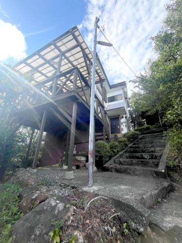 a house with a structure on top of some stairs at 熱海温泉自然郷の眺望の貸し切り in Atami
