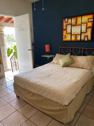 a bedroom with a large bed with a blue wall at Quinta Ángeles in Cuernavaca