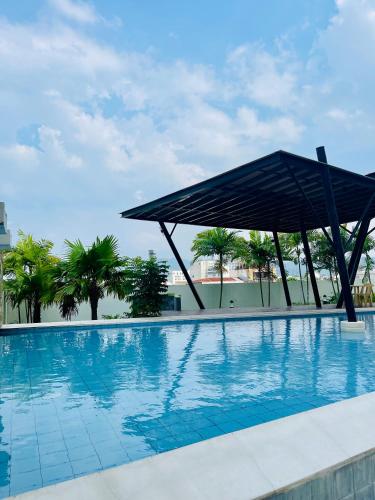 a large swimming pool with a large umbrella over it at Cozy Studio Unit at Centrio Tower beside Ayala Mall Downtown CDO in Cagayan de Oro