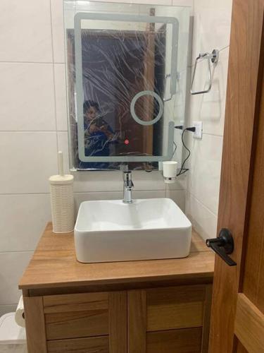 a bathroom with a white sink and a mirror at Brand New Beachfront Sunset Apartments in San Felipe de Puerto Plata