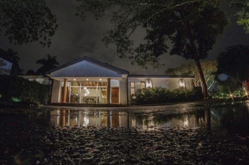 a house on a flooded street at night at Royal Garden Hotel Boutique in Cali