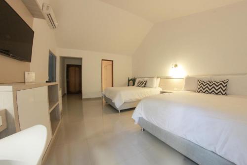 a hotel room with two beds and a flat screen tv at Royal Garden Hotel Boutique in Cali
