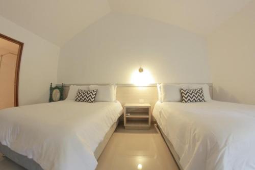two beds in a room with white walls at Royal Garden Hotel Boutique in Cali
