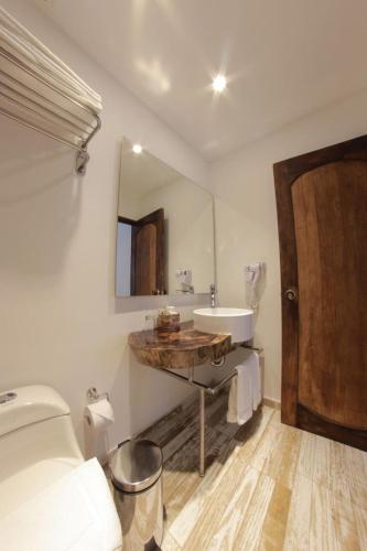 a white bathroom with a sink and a mirror at Royal Garden Hotel Boutique in Cali