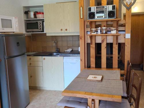 une petite cuisine avec une table et un réfrigérateur dans l'établissement Studio cabine confortable proche pistes ski, 4 pers. - FR-1-689-147, à Villard-de-Lans