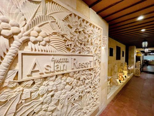 a building with a sign on the side of a wall at Hotel Asian Resort in Kōtōdaitōri