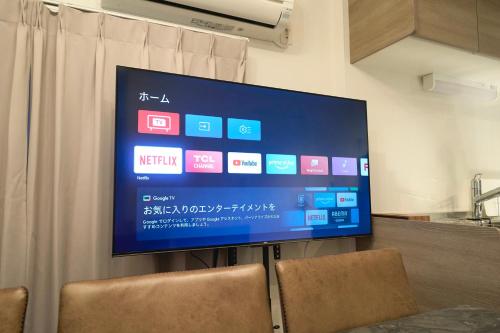 a large flat screen tv on a wall in a room at TOMARIE Residential Suite Kita-Senju in Tokyo