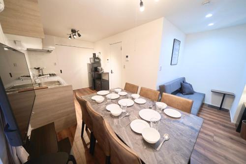 a dining room table with white plates on top of it at TOMARIE Residential Suite Kita-Senju in Tokyo