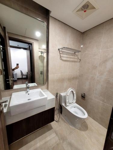 a bathroom with a sink and a toilet and a mirror at Na Mit HomeStay in Hai Phong