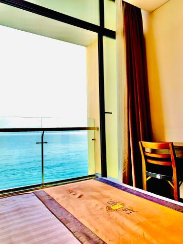 a bedroom with a large window with a view of the ocean at Lenid Ocean View Hotel in Nha Trang