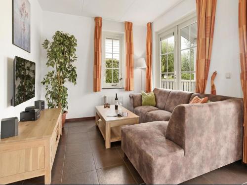 a living room with a couch and a table at Bungalow in South Holland with Private Jetty in Simonshaven