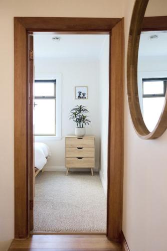 a bedroom with a mirror and a dresser with a plant at Waterfront home with outdoor spa bath and mountain views - 5 min drive to city in Montagu Bay