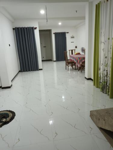a living room with a white marble floor and a table at Whits villa 24 in Matara