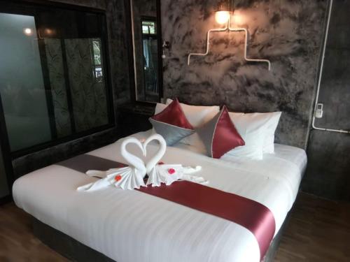 a bedroom with a bed with red and white pillows at Keeree Loft Resort คีรีลอฟท์รีสอร์ท in Thong Pha Phum