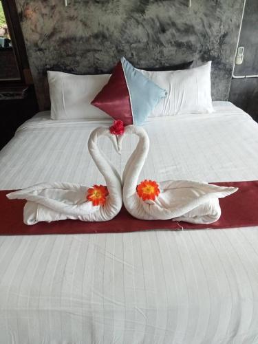 two swans made out of towels on a bed at Keeree Loft Resort คีรีลอฟท์รีสอร์ท in Thong Pha Phum