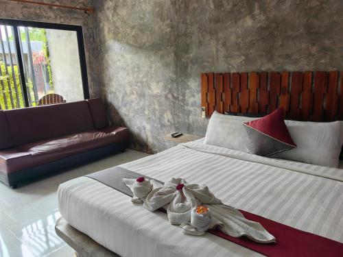 a bedroom with a bed with towels on it at Keeree Loft Resort คีรีลอฟท์รีสอร์ท in Thong Pha Phum