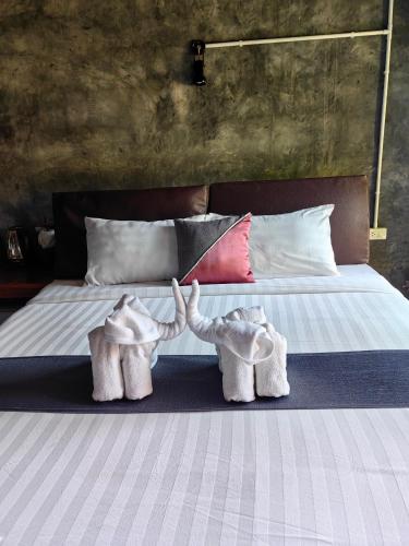 two stuffed elephants are standing on a bed at Keeree Loft Resort คีรีลอฟท์รีสอร์ท in Thong Pha Phum