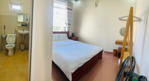 a bedroom with a bed and a bathroom with a toilet at Trà My Villa Đà Lạt BBQ Garden in Da Lat