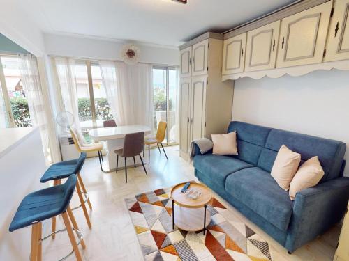 un salon avec un canapé bleu et une table dans l'établissement Studio RDJ avec terrasse, bord de mer, WIFI, animaux acceptés - FR-1-196-367, à Roquebrune-Cap-Martin
