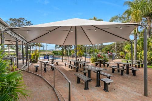a group of benches with a large umbrella at Mountain View Resort in Shoalhaven Heads