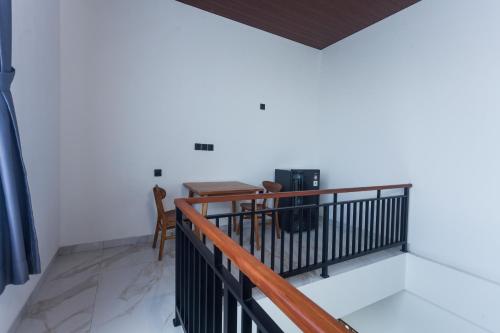 a room with a balcony with a table and a chair at Sujiwa Ubud Hotel & Villa in Ubud