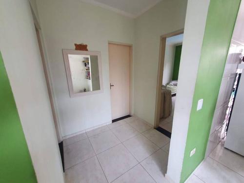 a room with a hallway with green walls and a mirror at Linda Casa Com Vista Pro Mar in Ilha Comprida