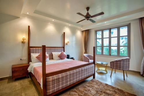 a bedroom with a bed and a ceiling fan at Hotel Sea Castle in Calangute