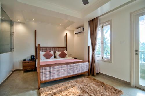 a bedroom with a bed and a window at Hotel Sea Castle in Calangute