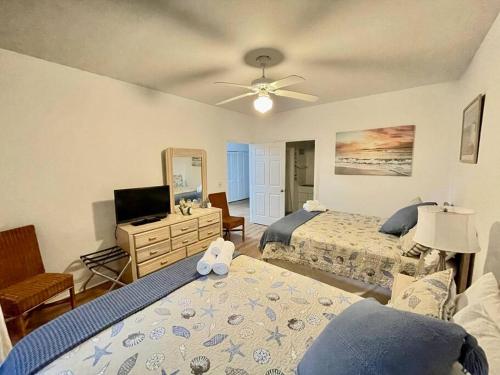a bedroom with two beds and a television in it at Amazing Newly Renovated Condo at Sea Trail Resort in Sunset Beach