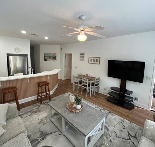un salon avec une télévision à écran plat et une table dans l'établissement Amazing Newly Renovated Condo at Sea Trail Resort, à Sunset Beach