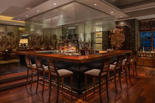 a bar in a restaurant with stools around it at The St. Regis Bali Resort in Nusa Dua