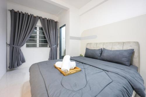 a bedroom with a blue bed with a towel on it at Premium Family Homestay in Cameron Highlands Clover Home 1-06 in Brinchang