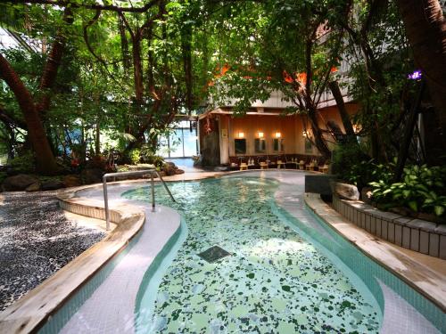 a swimming pool in a garden with trees at 泰泉閣 in Asakura