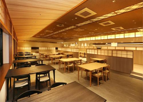 朝倉市にある泰泉閣の木製のテーブルと椅子が置かれた空のレストラン